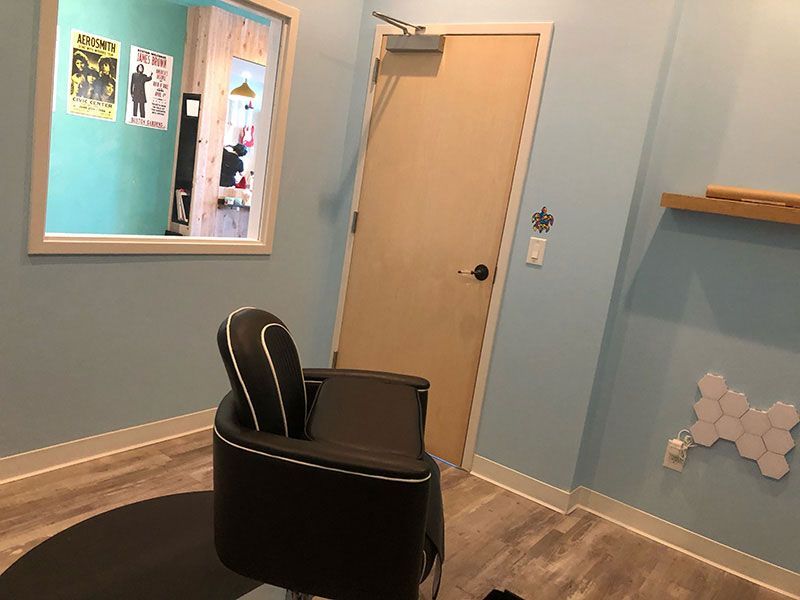 A chair in a room with a mirror and a door.