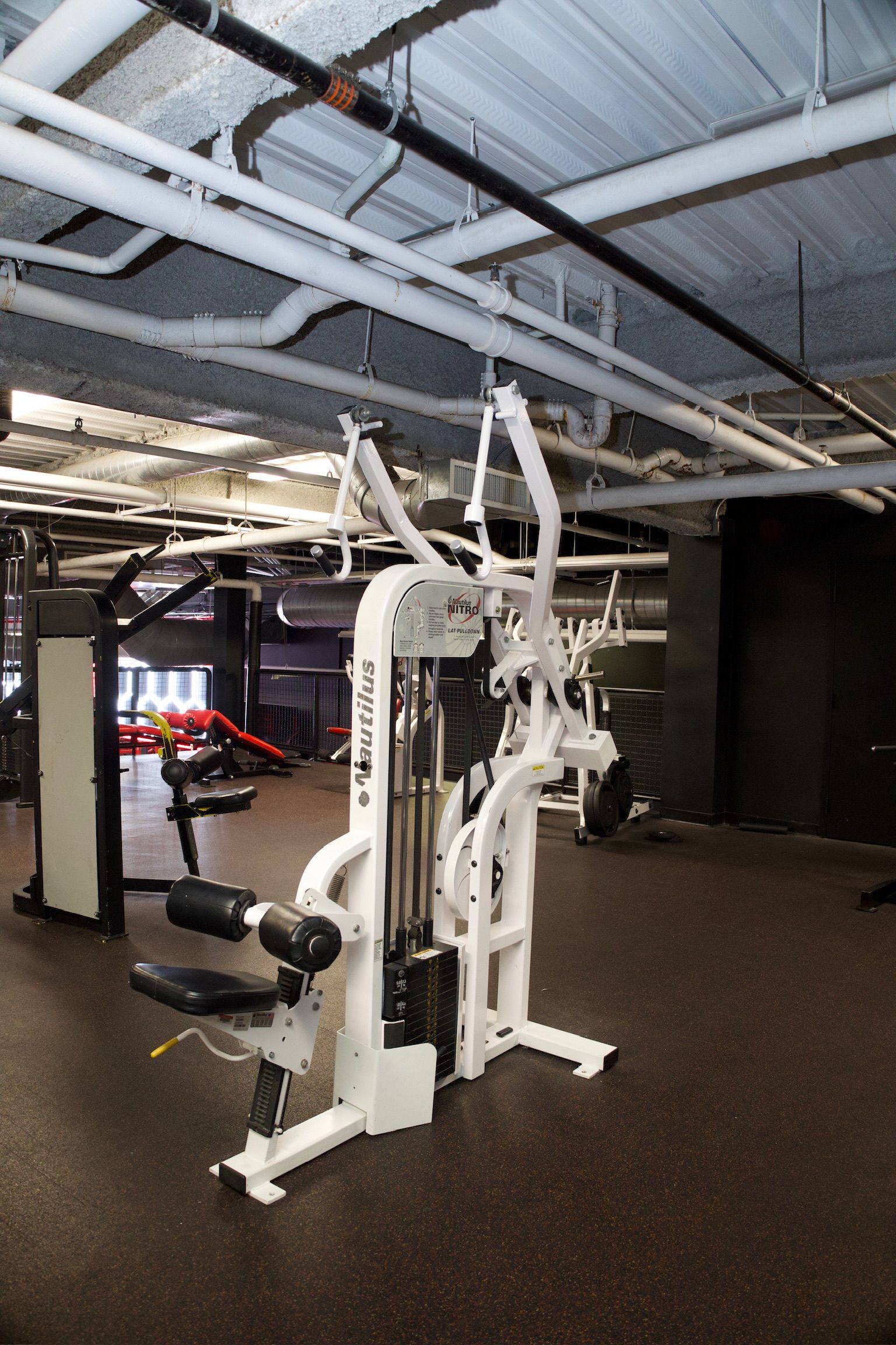 A white weight machine in a gym setting.