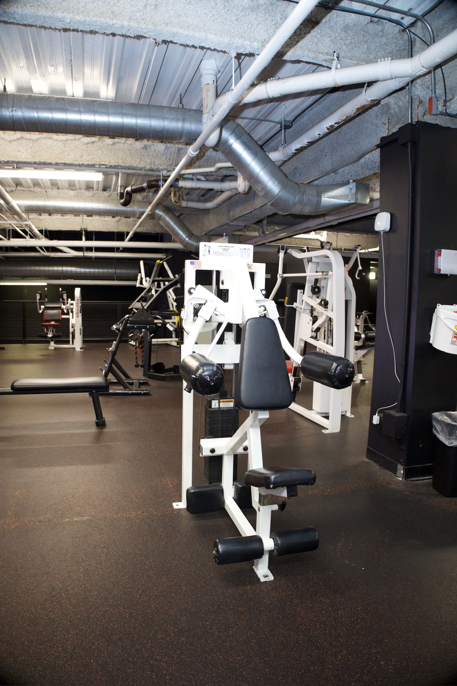 Gym interior with exercise machines, including a seated chest press.