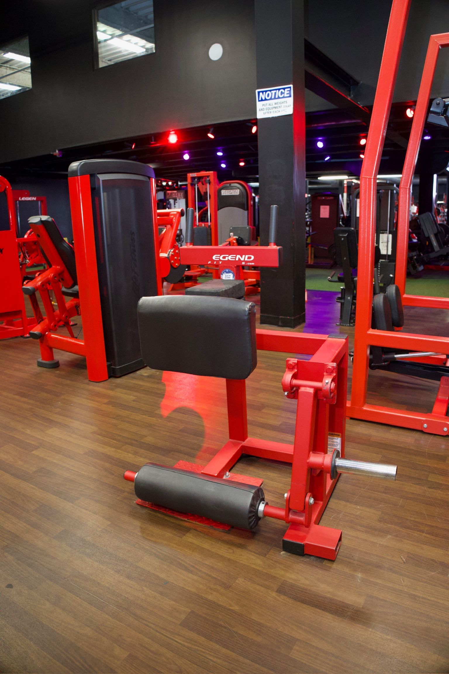 Red leg extension machine in a gym setting.