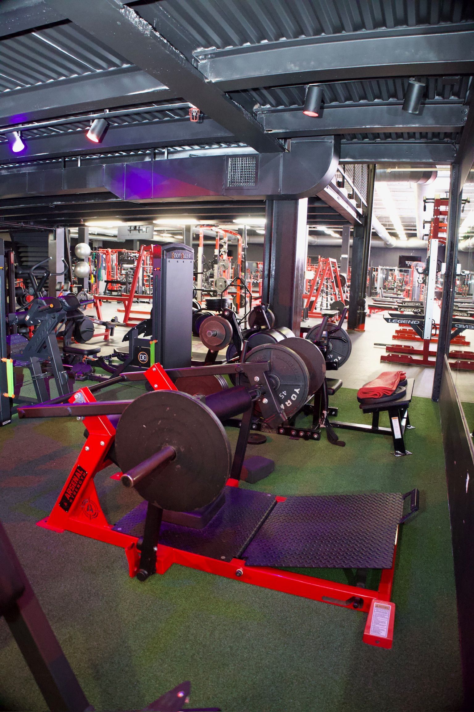 Red and black gym interior with weightlifting equipment.