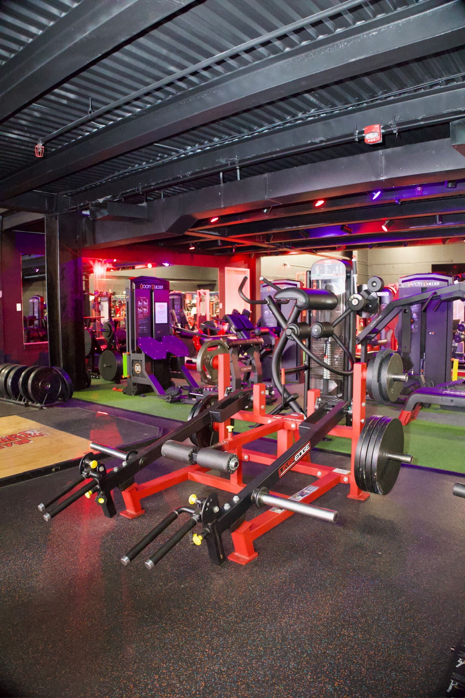 Weightlifting machine in a gym with red and black accents.