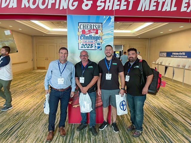 A group of men are standing in front of a sign that says cherish