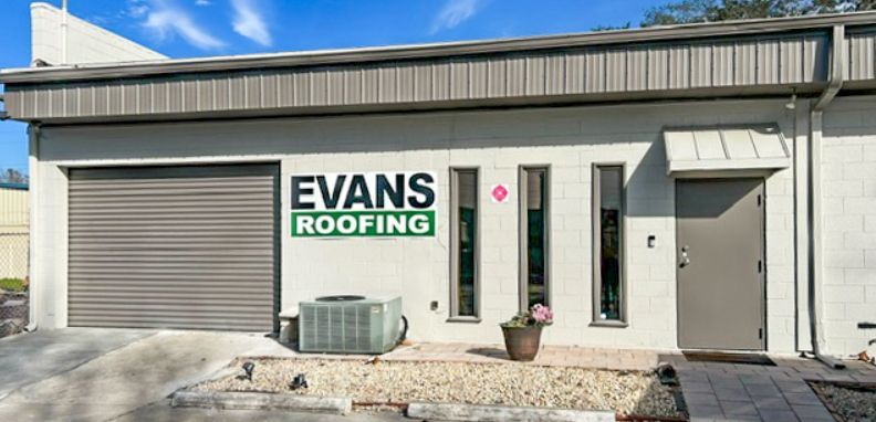 A white building with a sign that says evans roofing on it