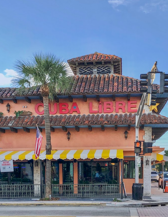 The front of a restaurant called cuba libre with a palm tree in front of it