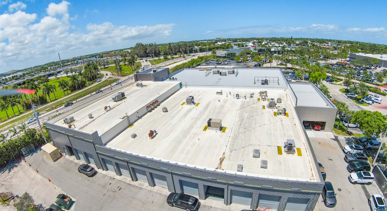 An aerial view of a large building with a white roof