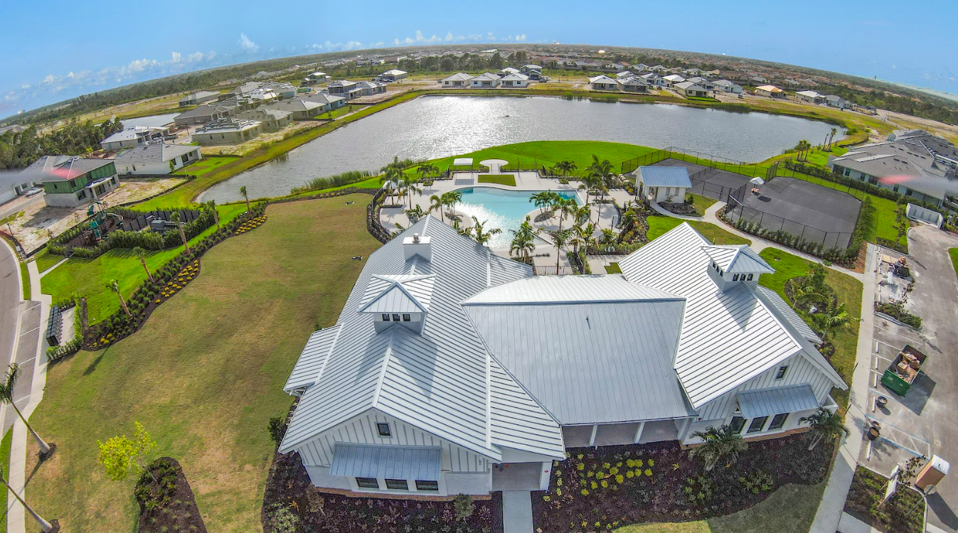An aerial view of a house with a pool and a lake in the background