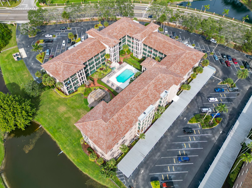 An aerial view of a large apartment building with a pool in the middle