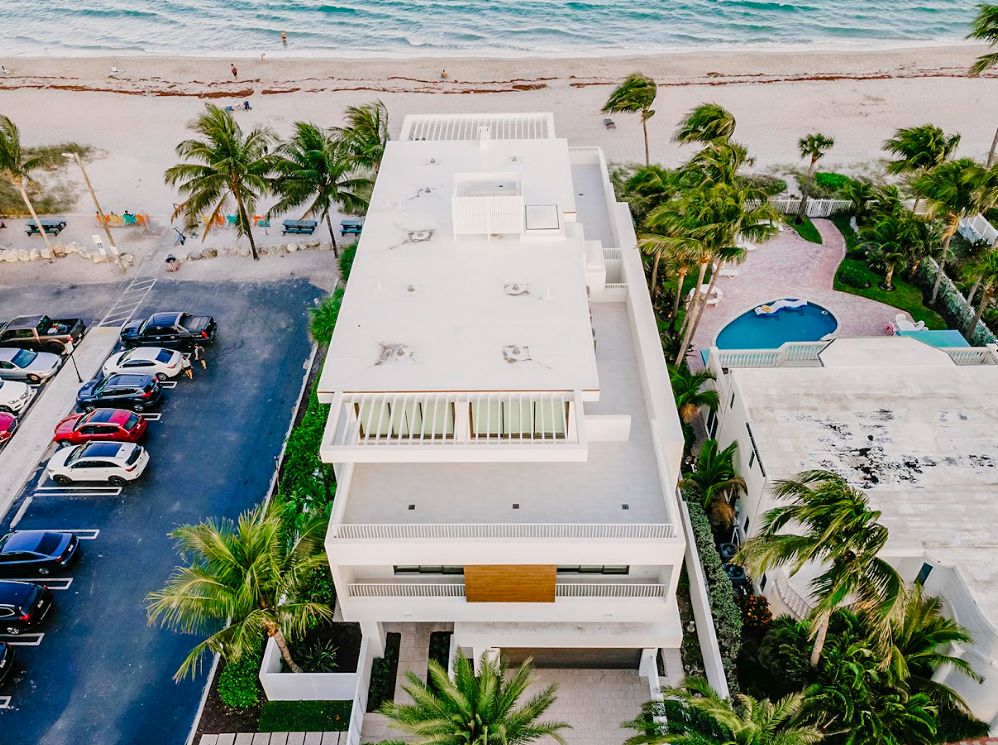 An aerial view of a building next to a beach