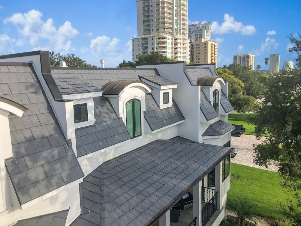 An aerial view of a white house with a slate roof