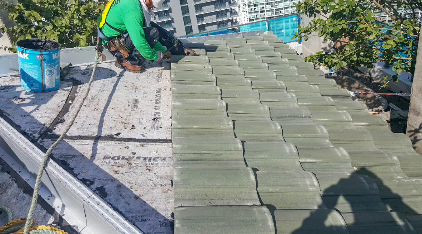 A man is sitting on top of a roof