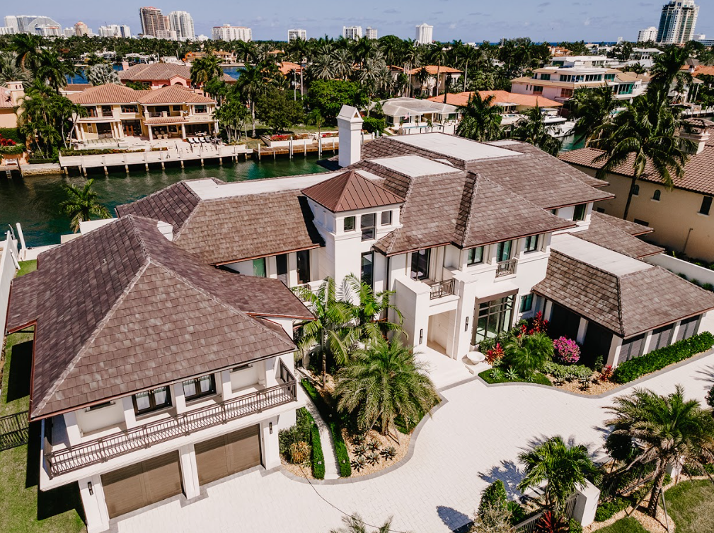 An aerial view of a large house with a lot of cars parked in front of it