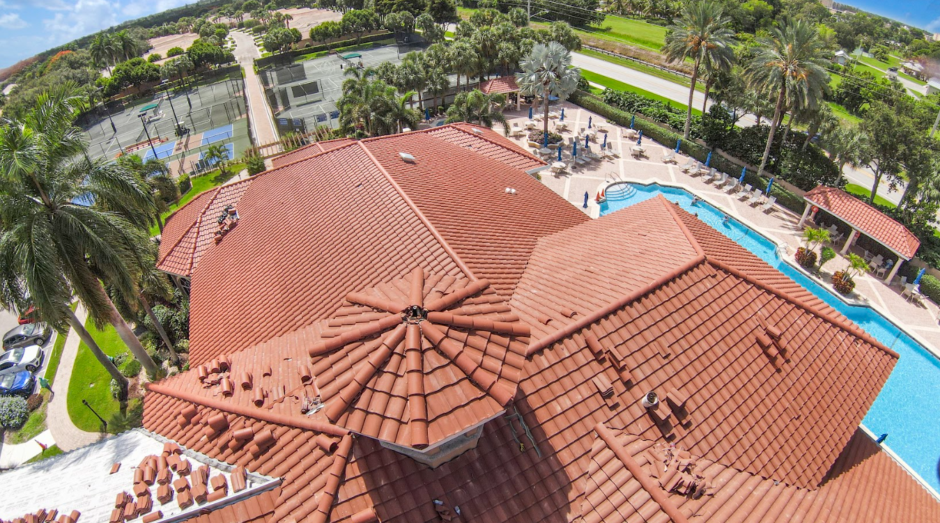 An aerial view of a large house with a pool and tennis courts