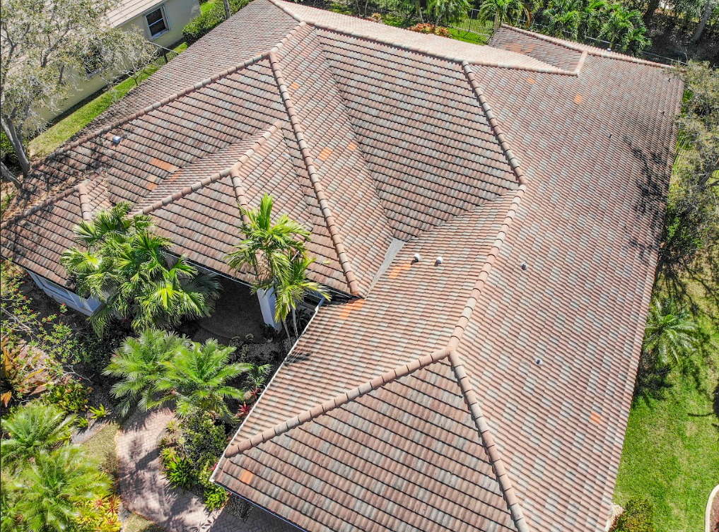 An aerial view of a house with a tiled roof and palm trees