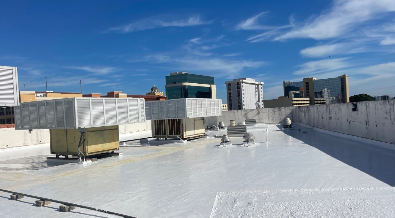 The roof of a building with a white roof and a blue sky in the background