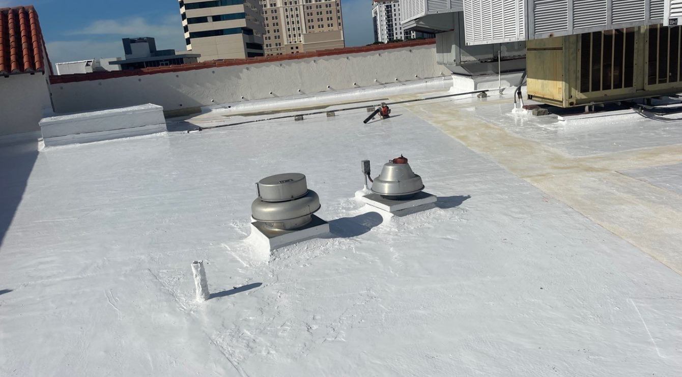 A roof with a few fans on it and a building in the background