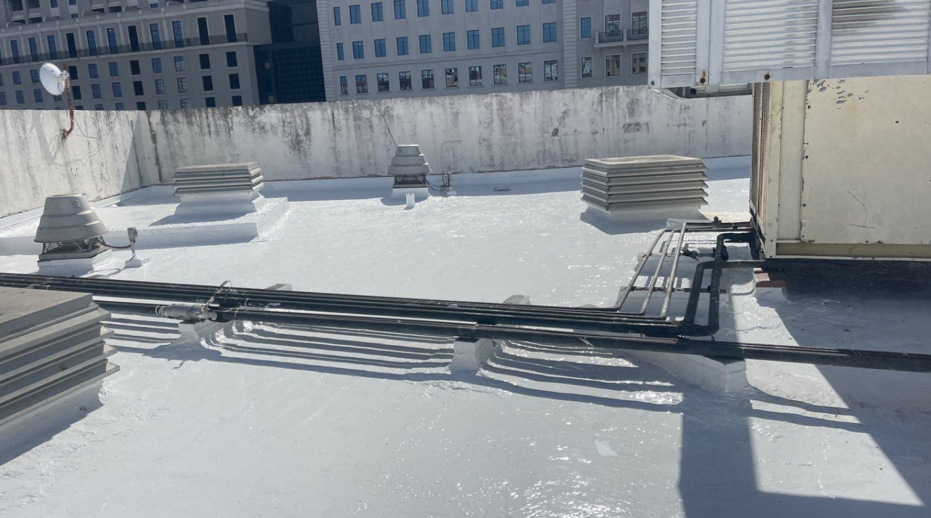 A roof with a lot of wires on it and a building in the background
