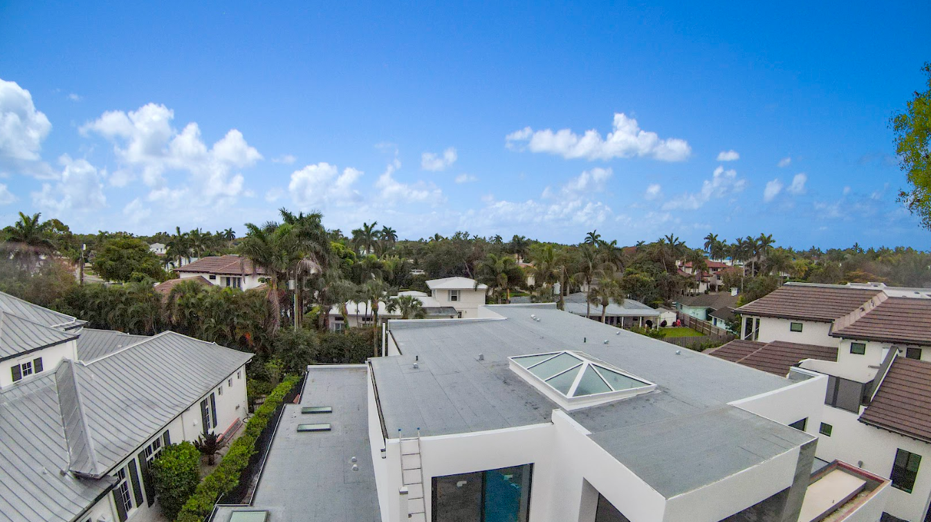 An aerial view of a residential area with a skylight on the roof of a building