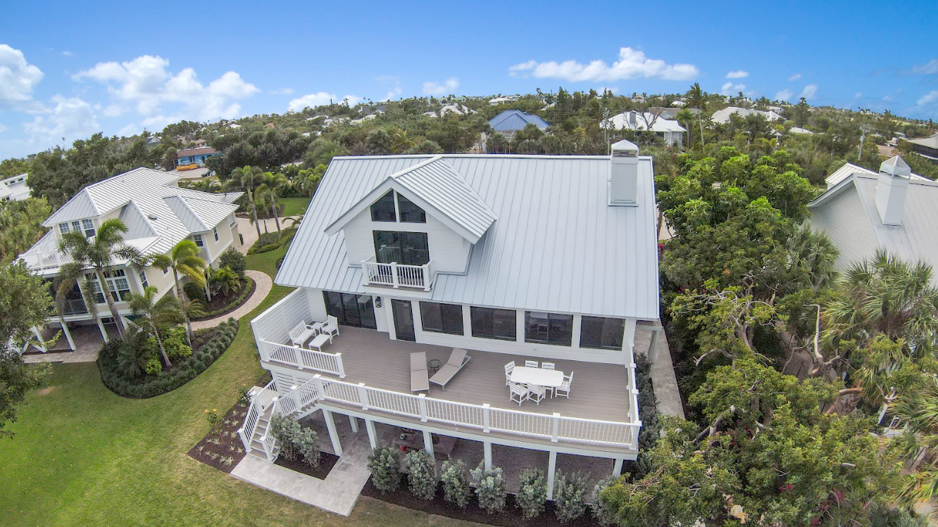 An aerial view of a large white house surrounded by trees