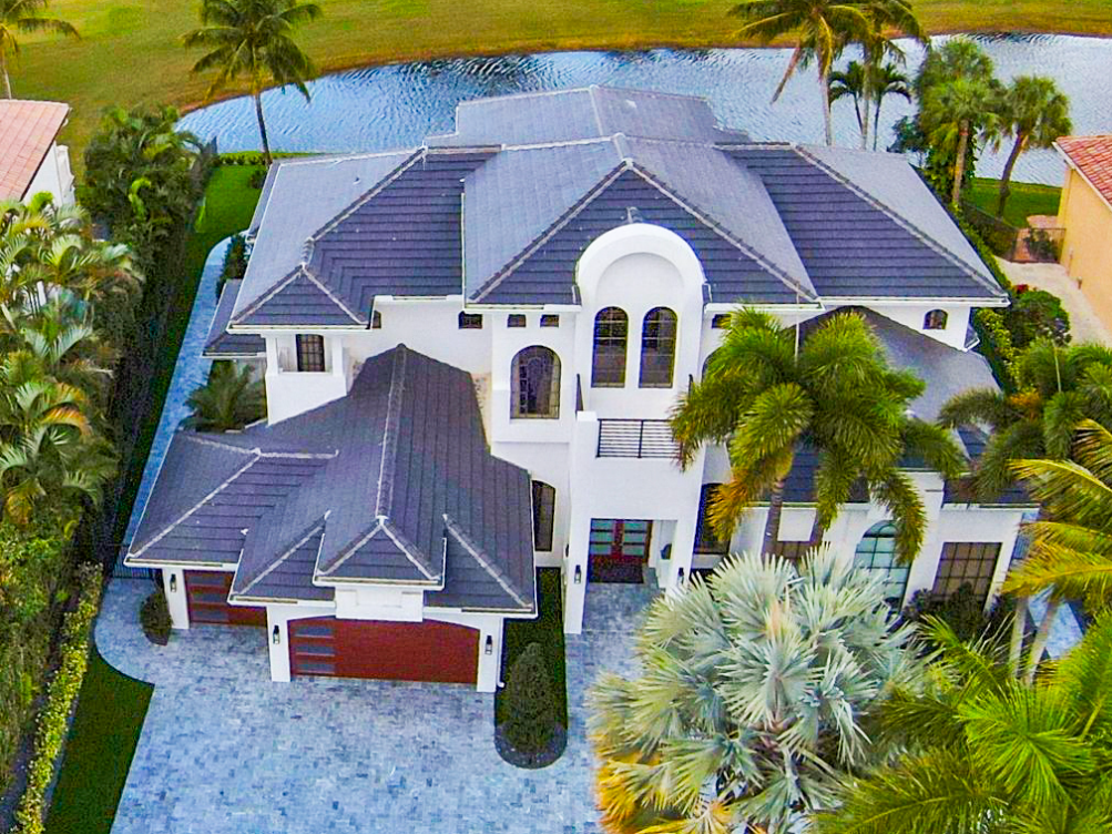 An aerial view of a large house surrounded by palm trees