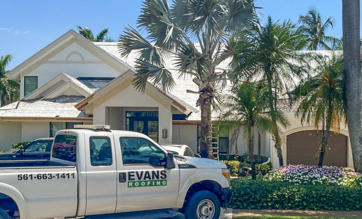 A white truck is parked in front of a house