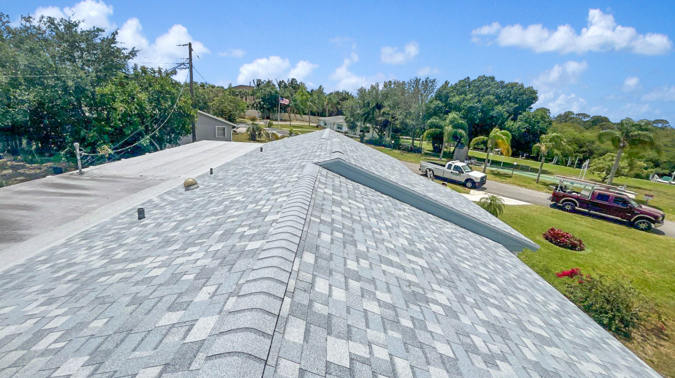 A roof with a lot of shingles is sitting on top of a lush green field