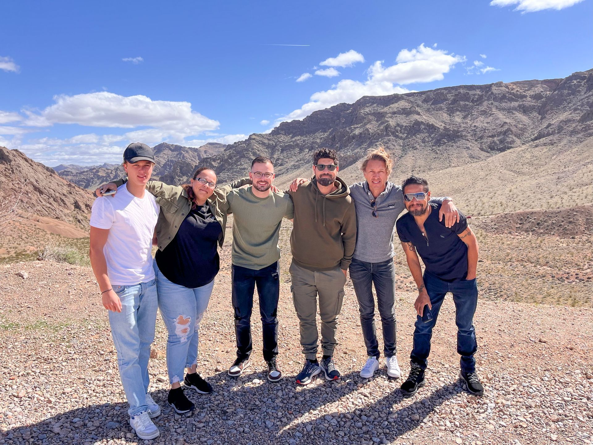 A group of people are posing for a picture in front of a mountain.