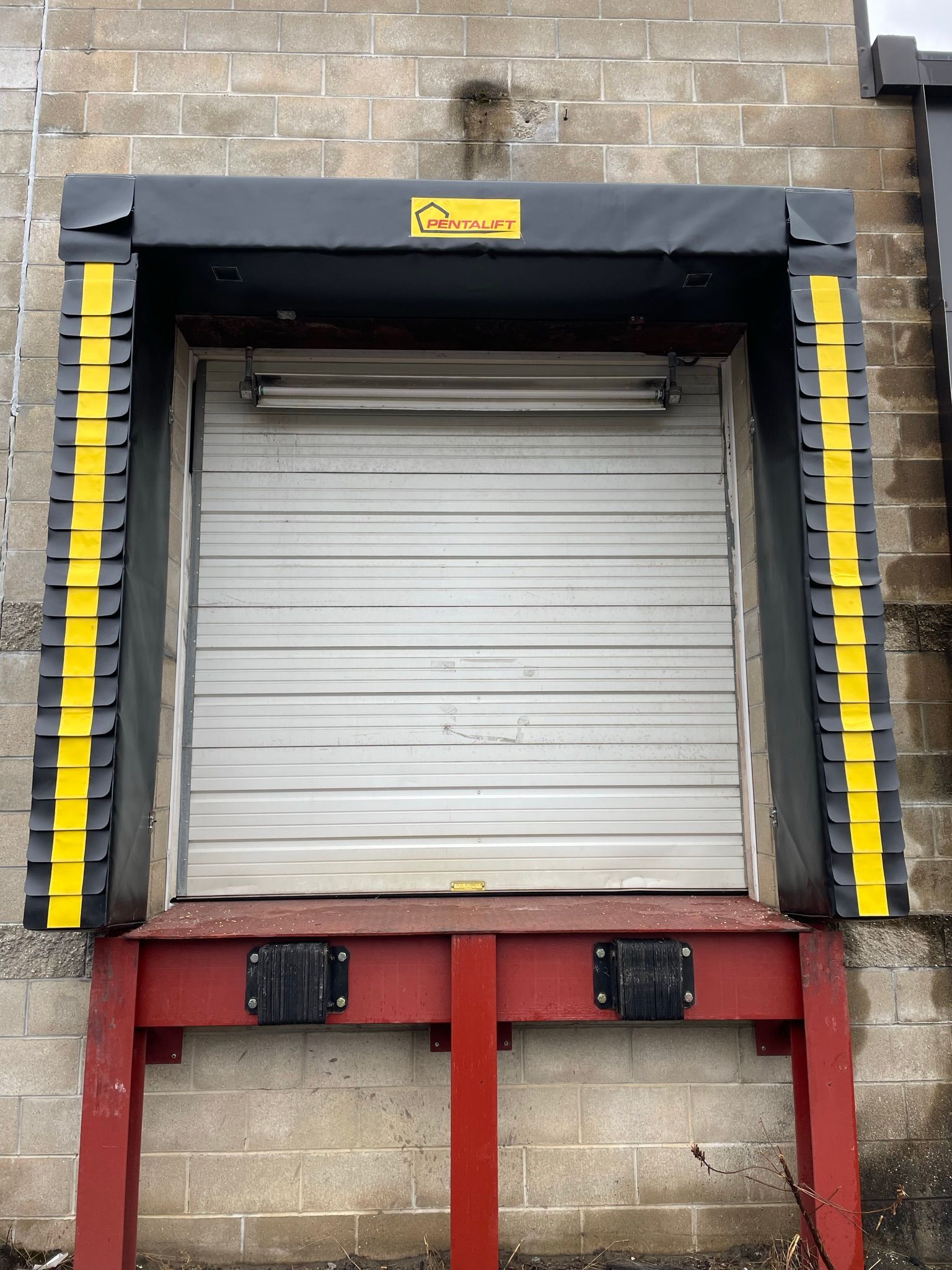 A warehouse door with a yellow and black stripe on it