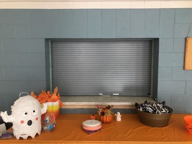 A table with a ghost piñata and a bowl of candy on it