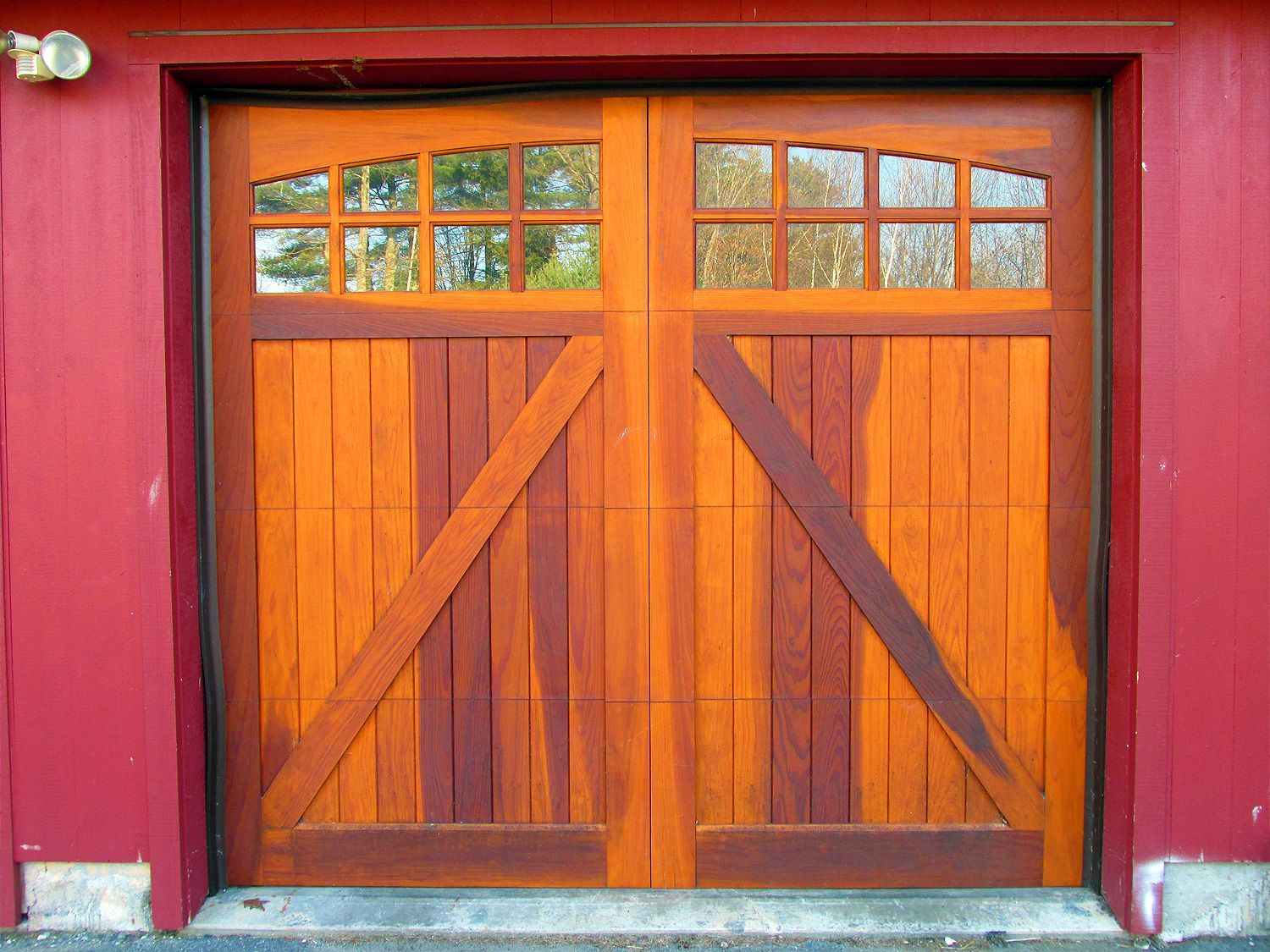 A wooden garage door with a red wall behind it