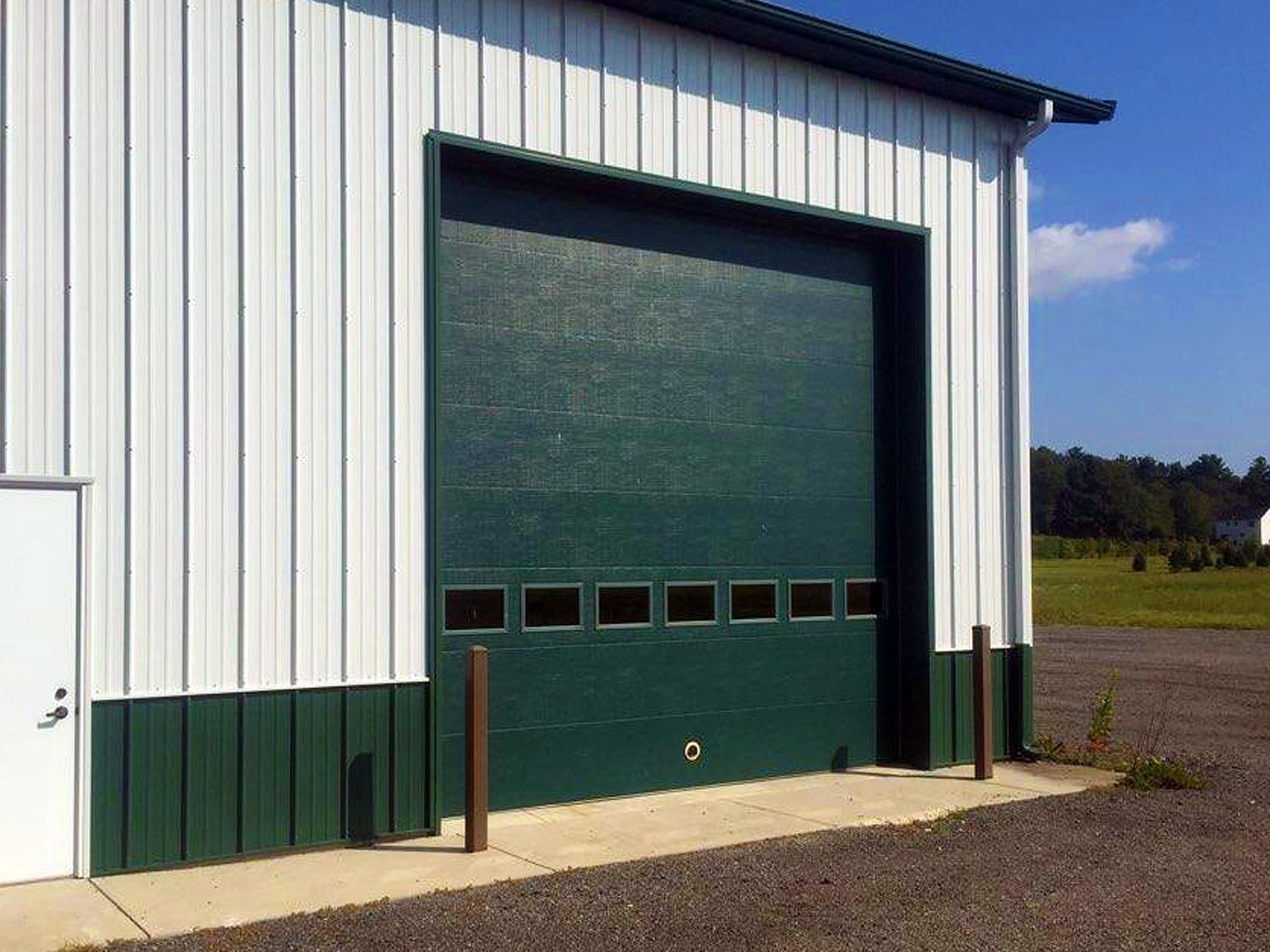 A white building with a green garage door
