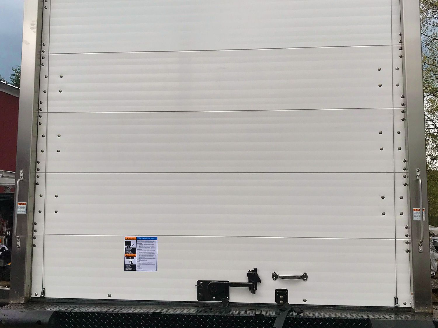 The back of a truck with a white door