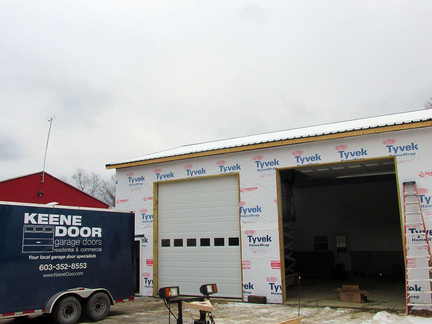 A trailer that says keene door is parked in front of a building