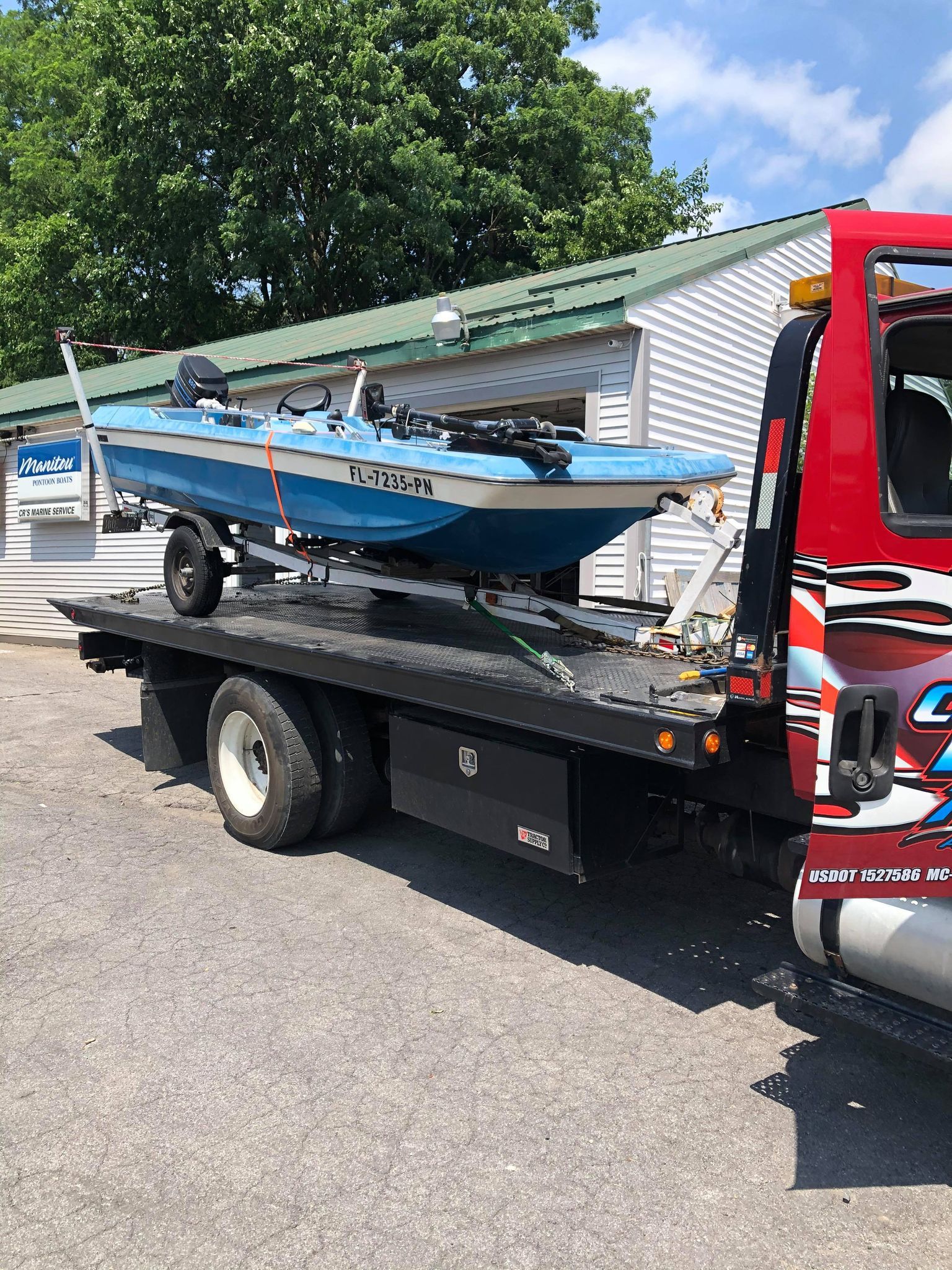 A boat is being towed by a tow truck.