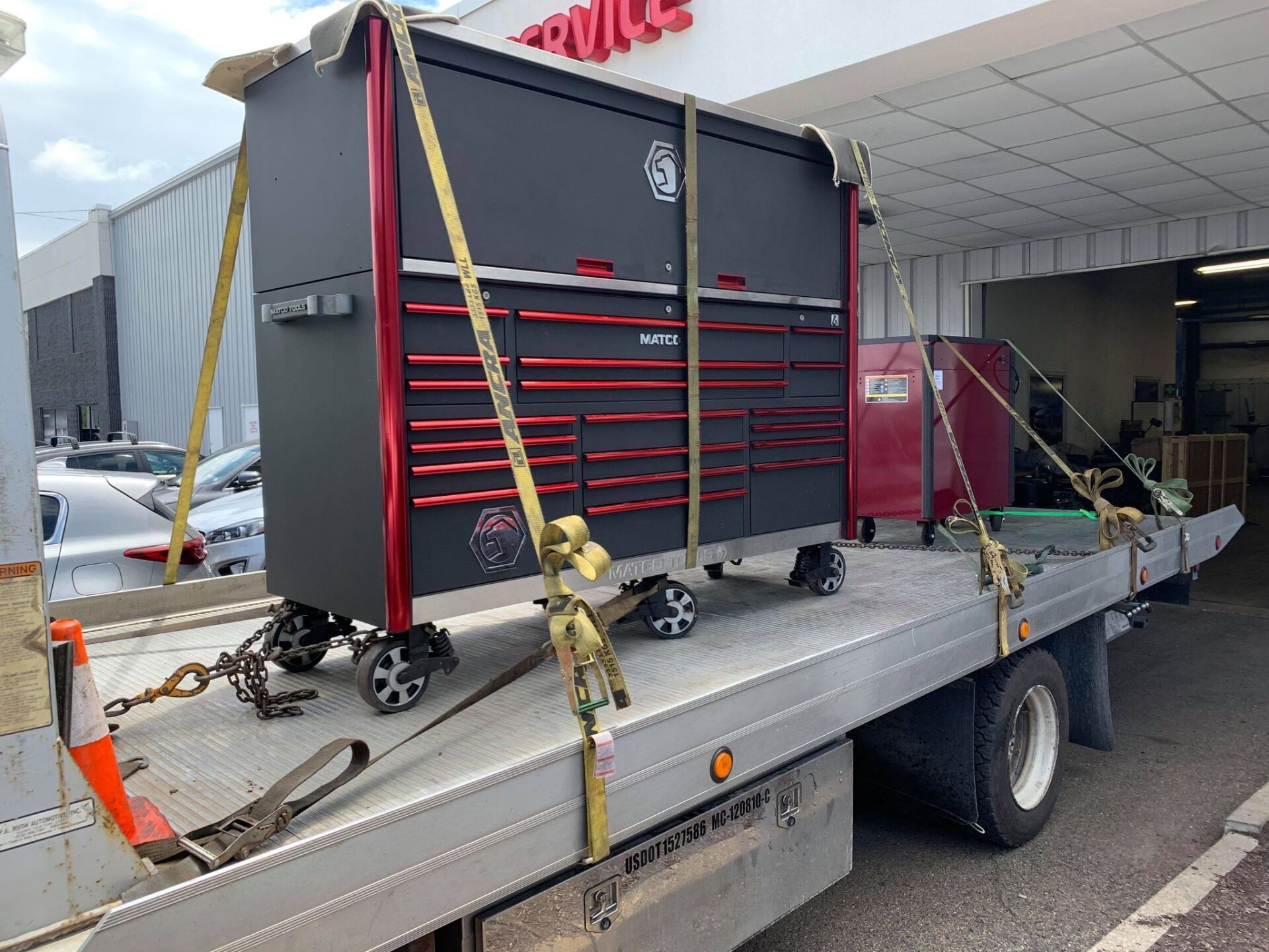 A large toolbox is sitting on the back of a tow truck.