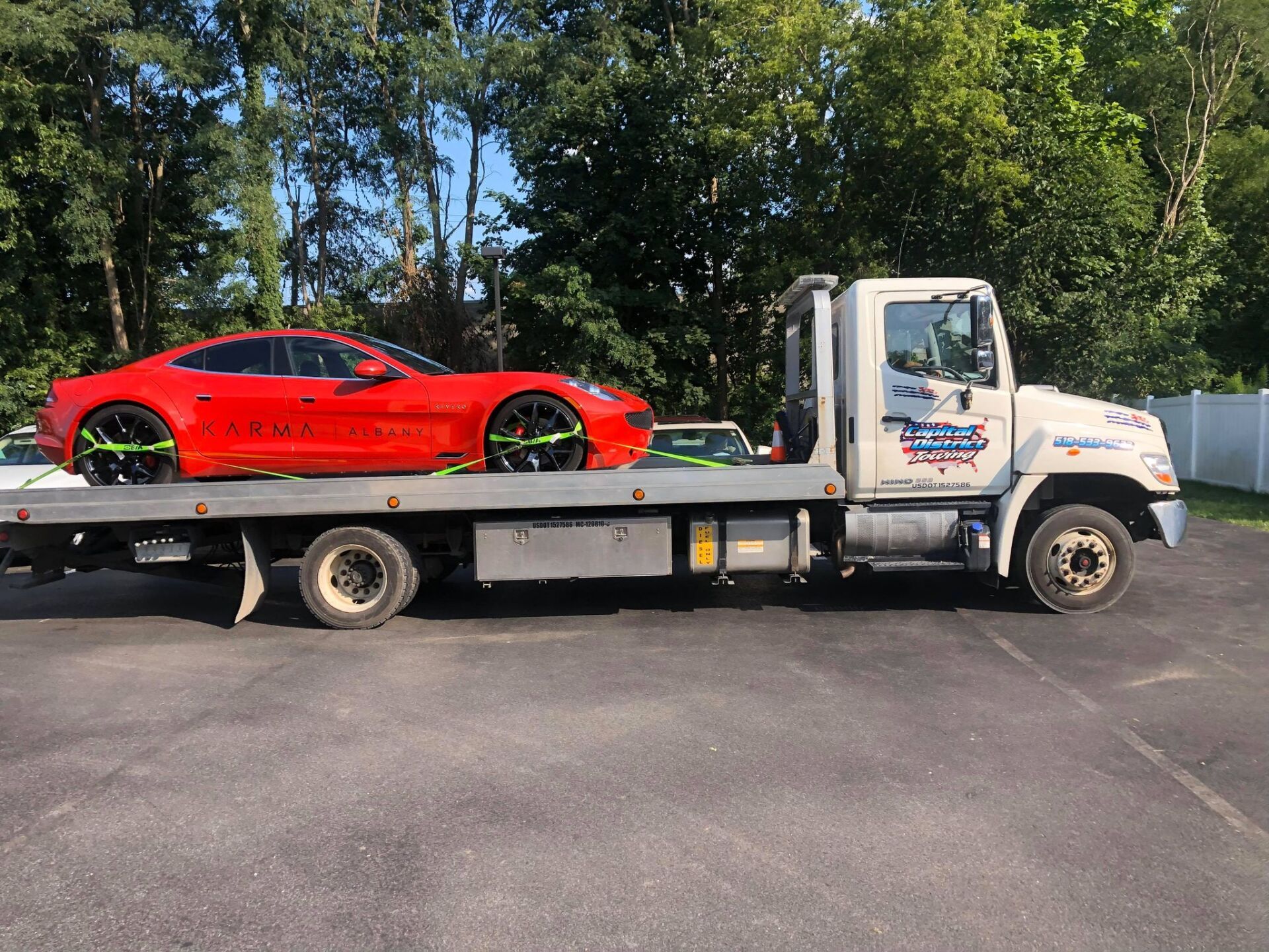 A red sports car is being towed by a tow truck.