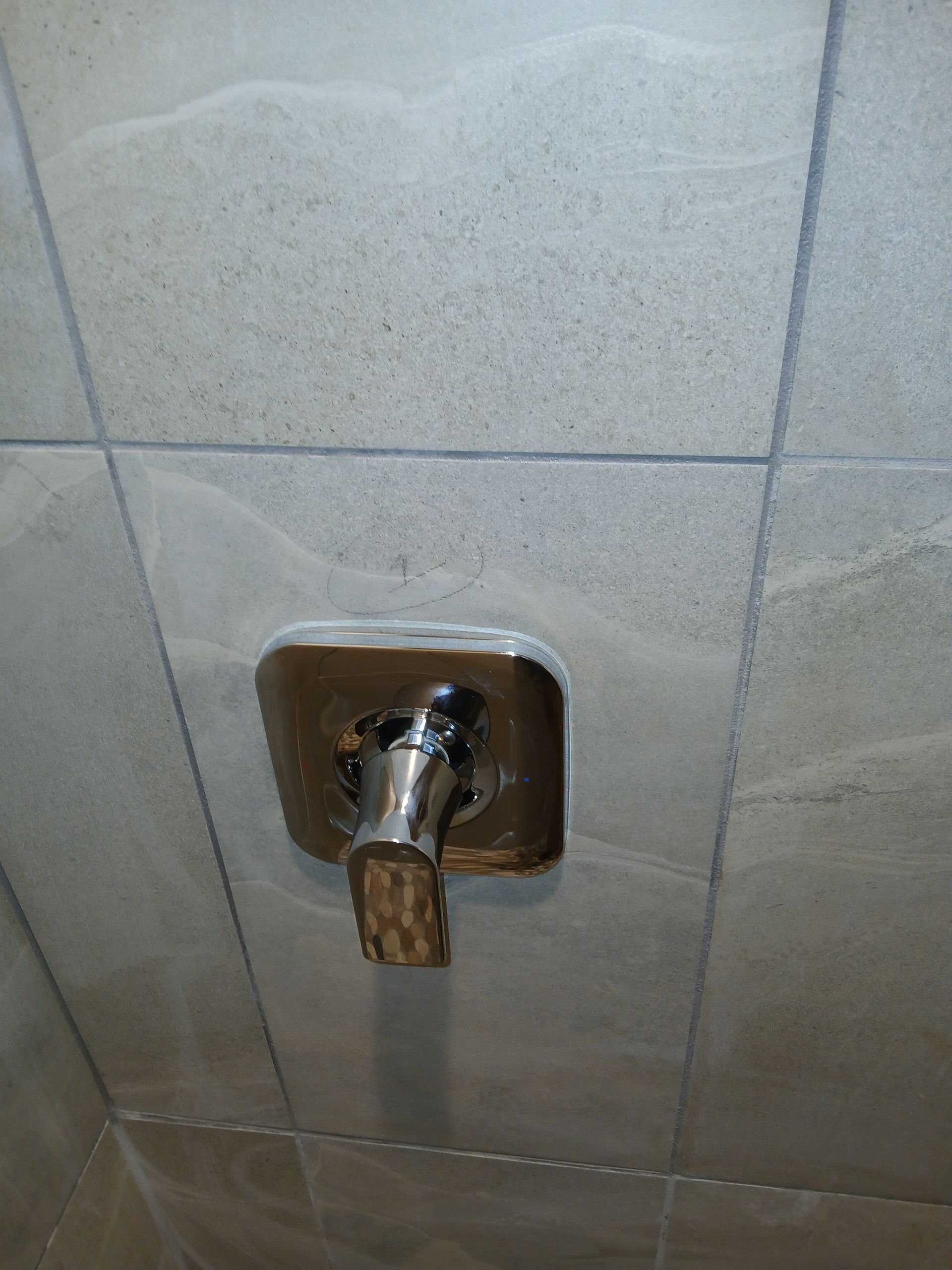 Chrome shower valve on tiled bathroom wall