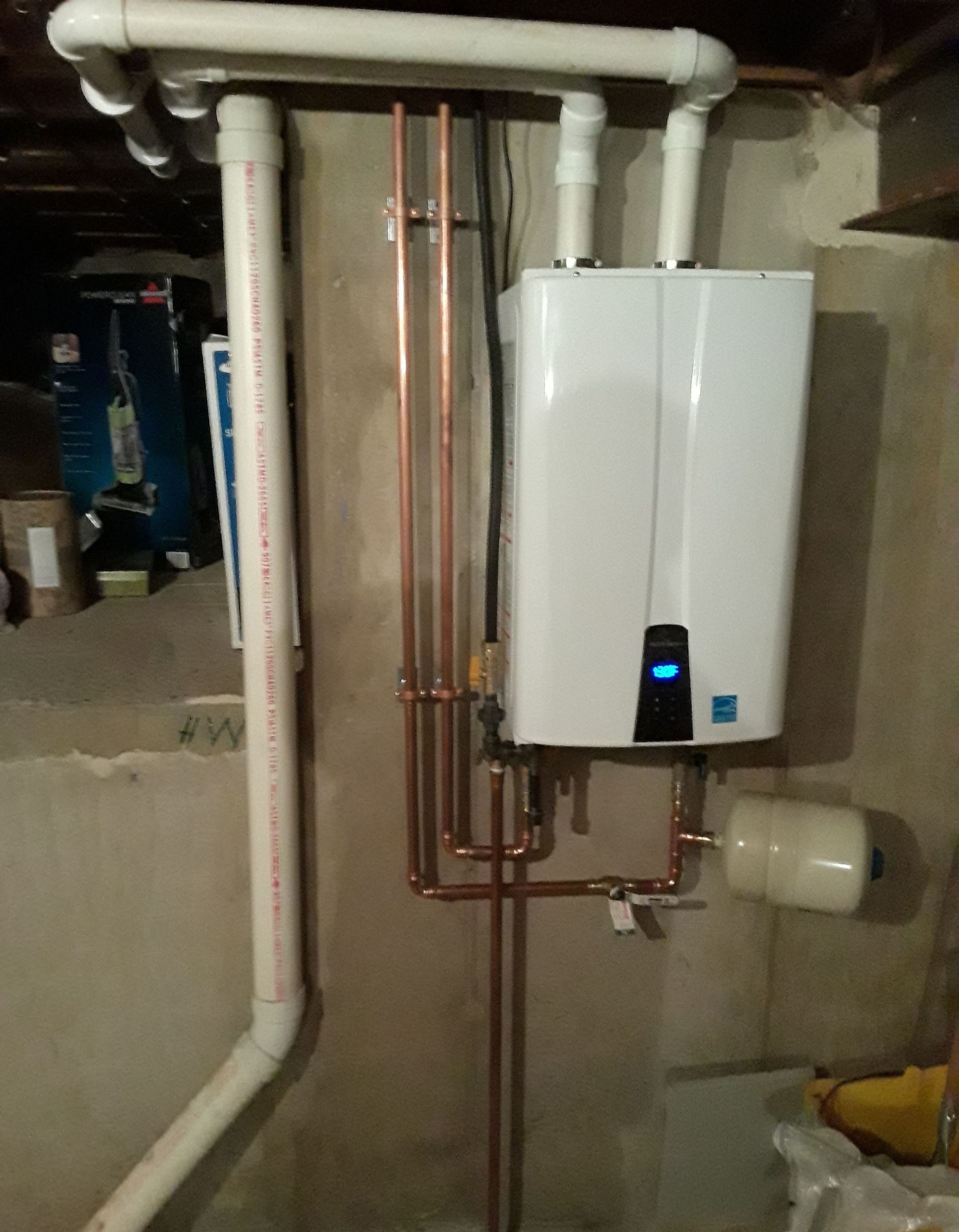 White wall-mounted boiler with copper pipes in a basement utility room