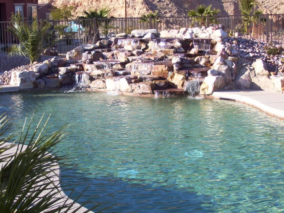 A large swimming pool with a waterfall in the background