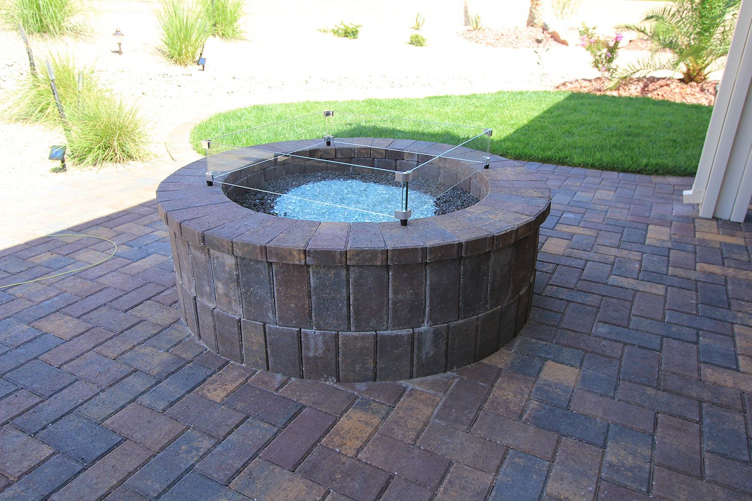 A fire pit is sitting on top of a brick patio.