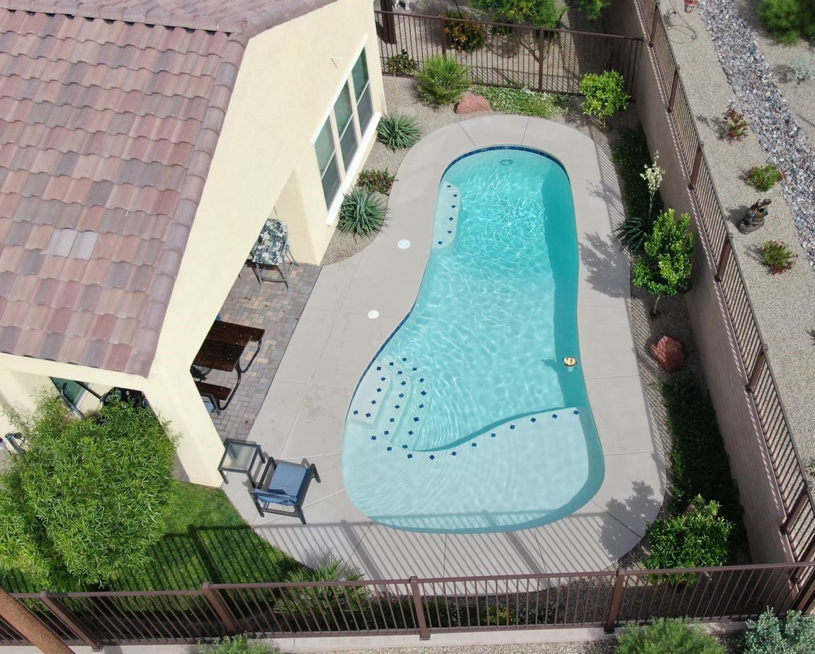 An aerial view of a house with a large swimming pool