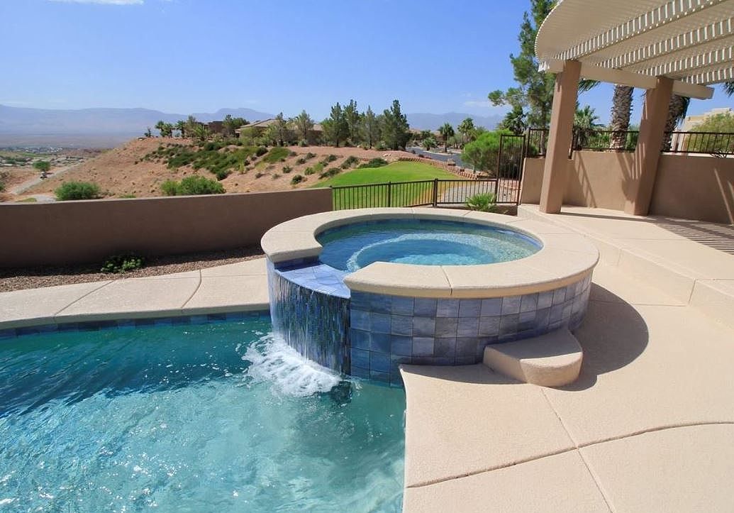 A swimming pool with a hot tub in the middle of it.