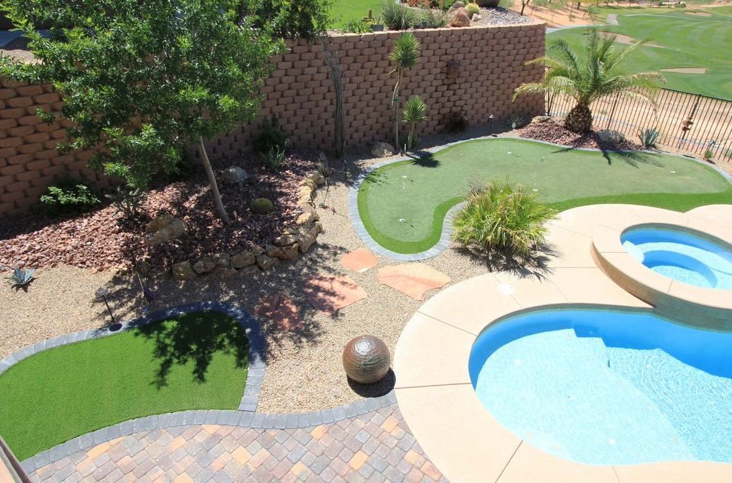 An aerial view of a backyard with a swimming pool and a putting green.