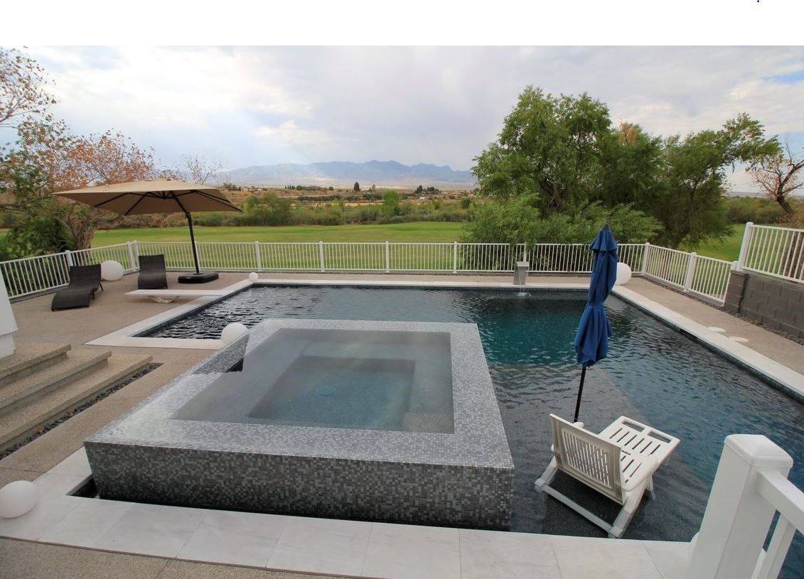 A large swimming pool with a hot tub in the middle