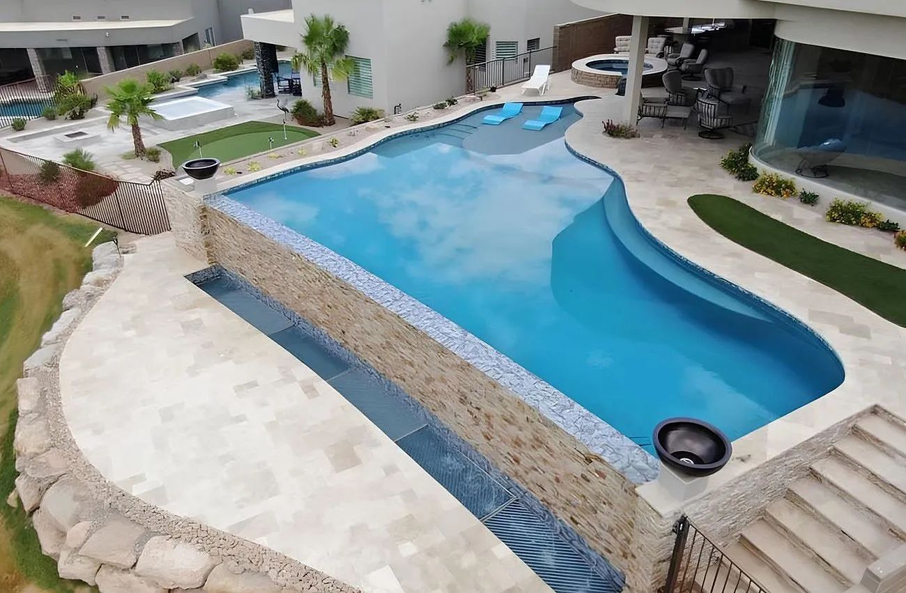 An aerial view of a large swimming pool in the backyard of a house
