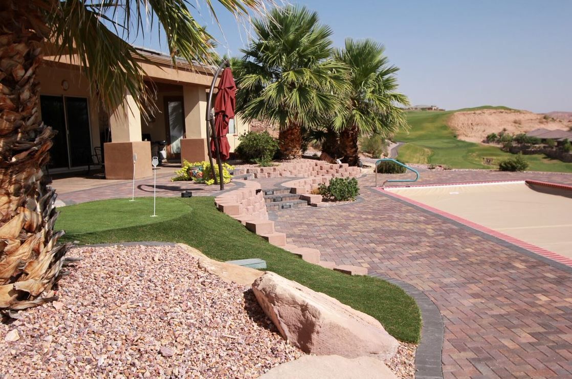 There is a small golf course in the backyard of a house.
