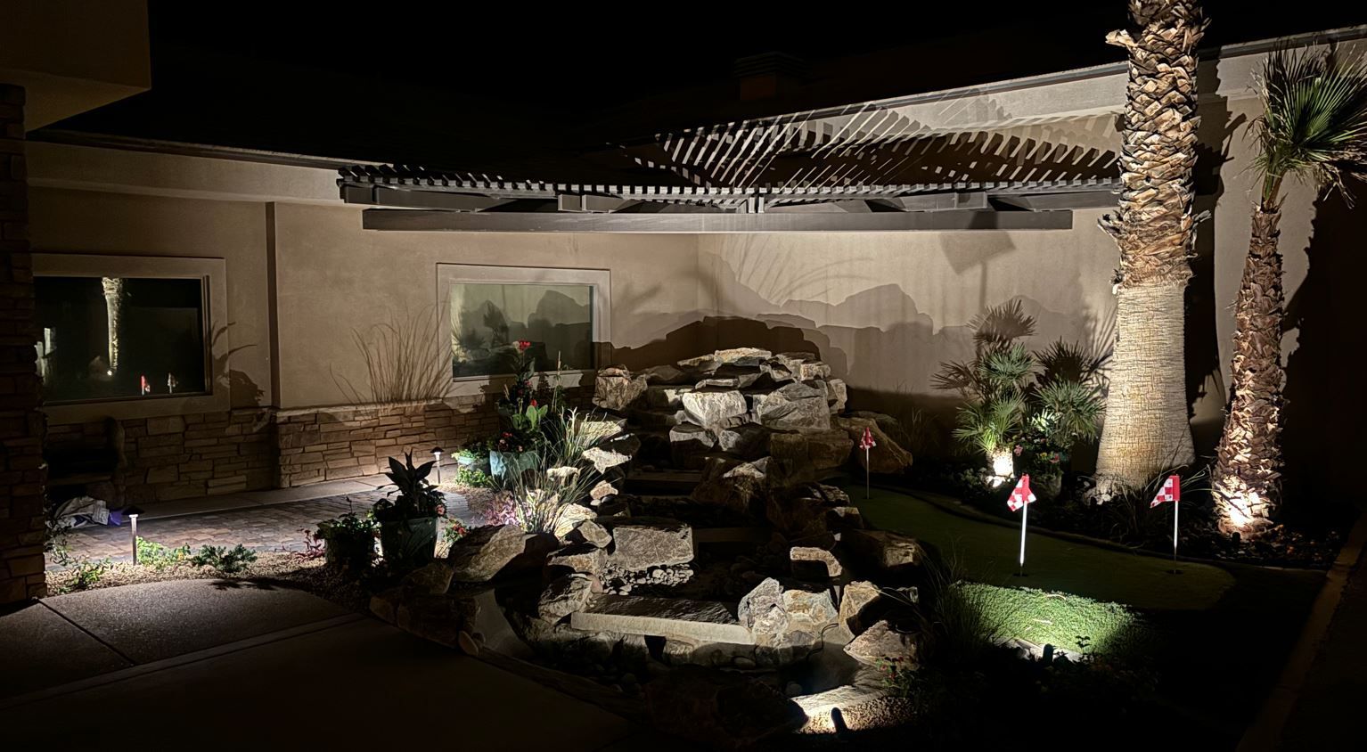 The backyard of a house is lit up at night.