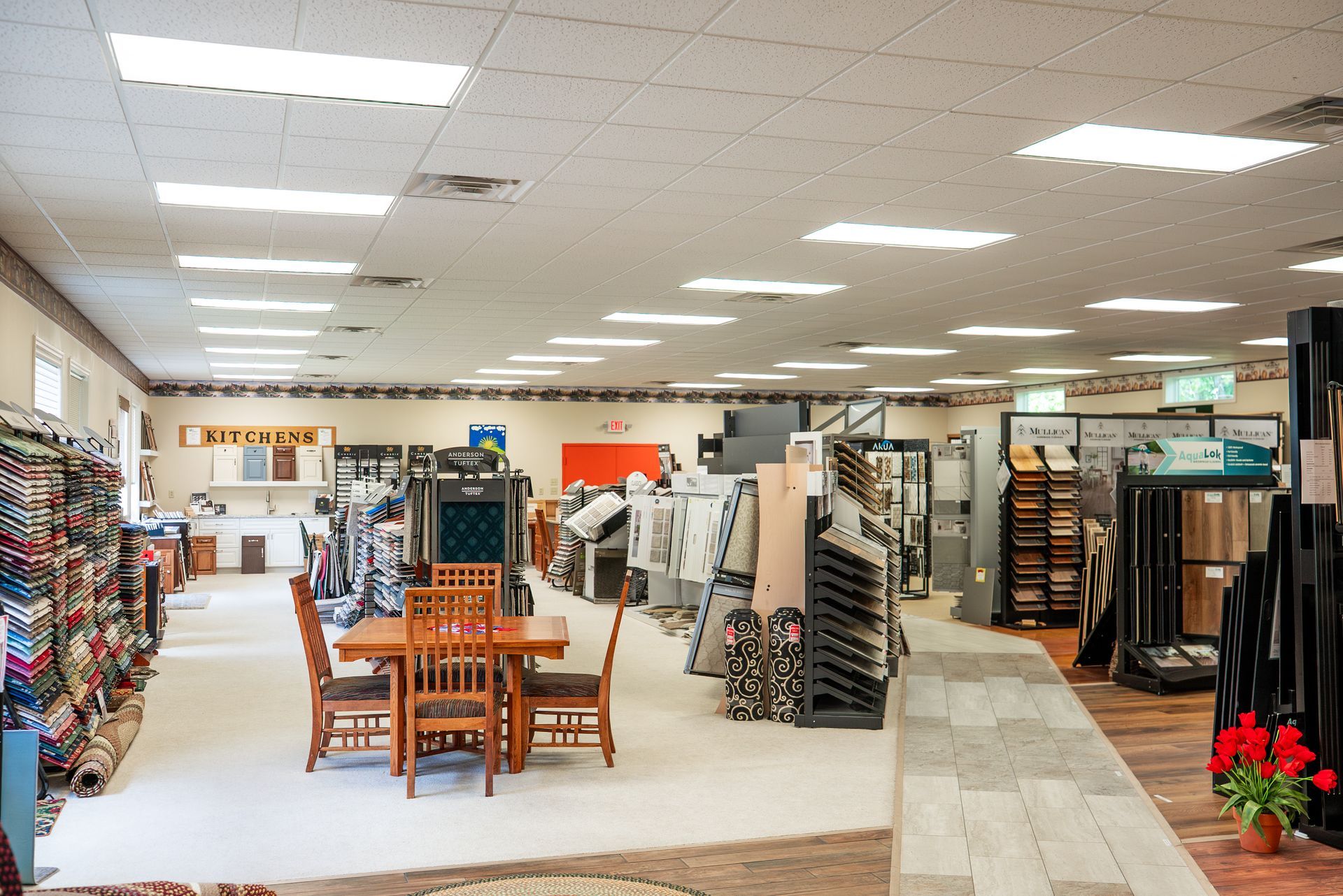 A stuffed giraffe is sitting on the stairs in a store