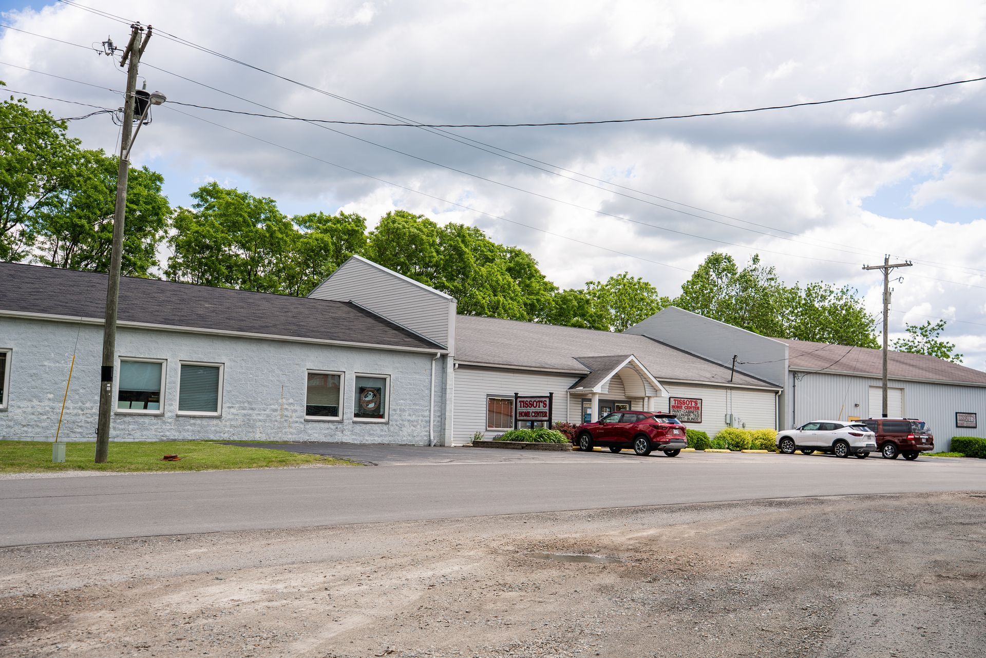 A red truck is parked in front of a white building
