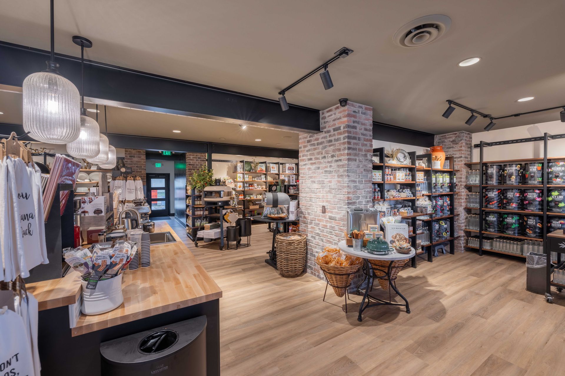 Cozy boutique interior with wooden floors, shelves of folded clothes, and hanging lights